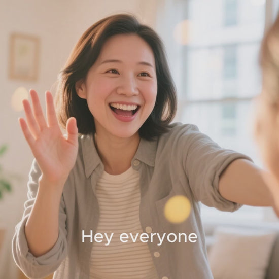 A smiling woman waving and greeting others, capturing a joyful moment in a bright living room.